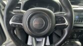 Close-up view of a Jeep steering wheel with integrated controls and the dashboard visible in the background.
