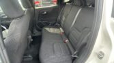 Rear interior of a car showing a black cloth three-seat bench with headrests and visible seat belts by the doors.
