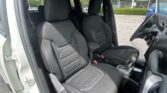 Interior of a right-hand-drive car with black fabric front seats, center console, and steering wheel on the right side.