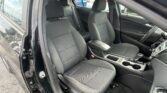 Front seating area of a black car with open front passenger door, showing two gray fabric seats and center console between them.