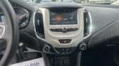 Center console car interior with touchscreen radio showing 104.1 FM and climate controls; window view outside.