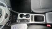 Interior of a car: center console with gear shift, cup holders, and passenger seat visible