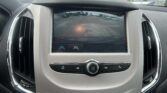 In-car rearview camera display showing a parking lot with red guideline lines behind the vehicle.
