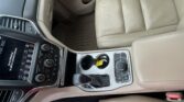 Front car interior with beige leather seats, center console, gear shifter, and cup holders visible from above