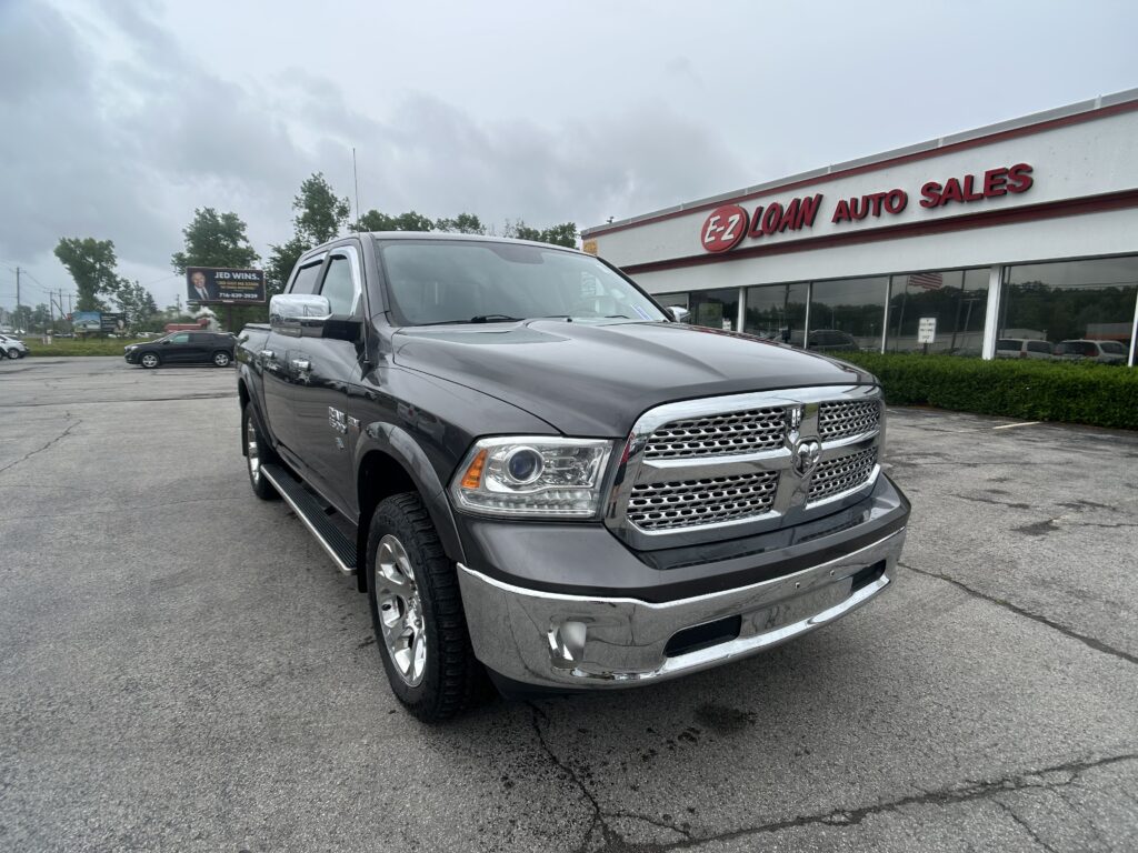 Front and right-side view of a gray pickup truck parked in a car lot in front of EZ Loan Auto Sales storefront with a bold red sign above the windows.