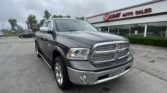Front and right-side view of a gray pickup truck parked in a car lot in front of EZ Loan Auto Sales storefront with a bold red sign above the windows.