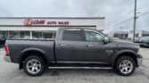 Gray Ram 1500 pickup truck parked in front of the E-Z LOAN Auto Sales storefront sign.