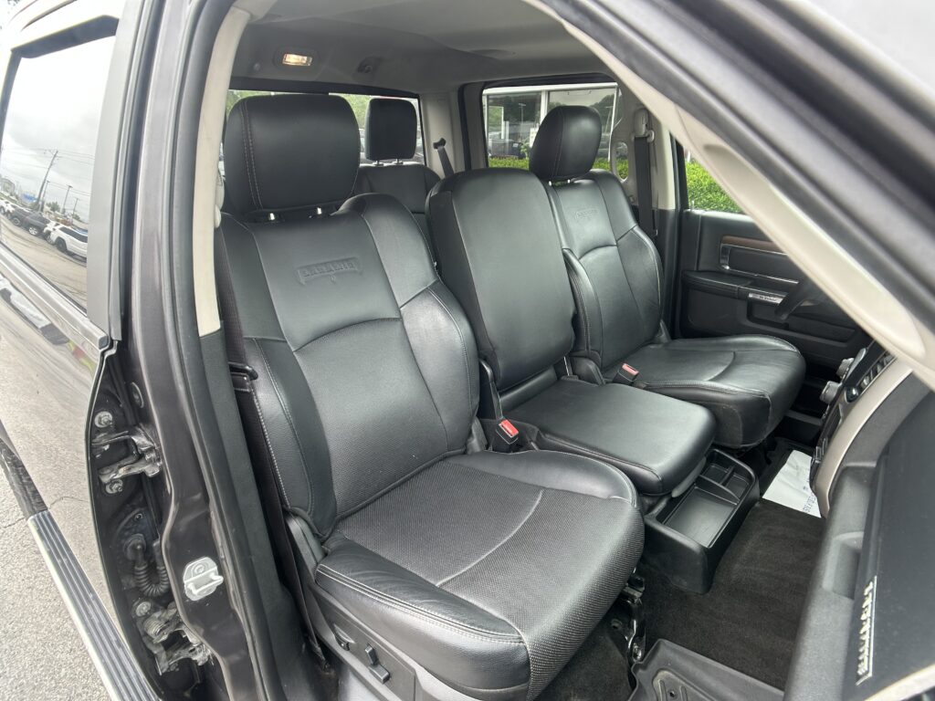 Interior of a black leather SUV with front seats visible and the passenger door open, showing the dashboard area.