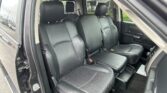 Interior of a black leather SUV with front seats visible and the passenger door open, showing the dashboard area.