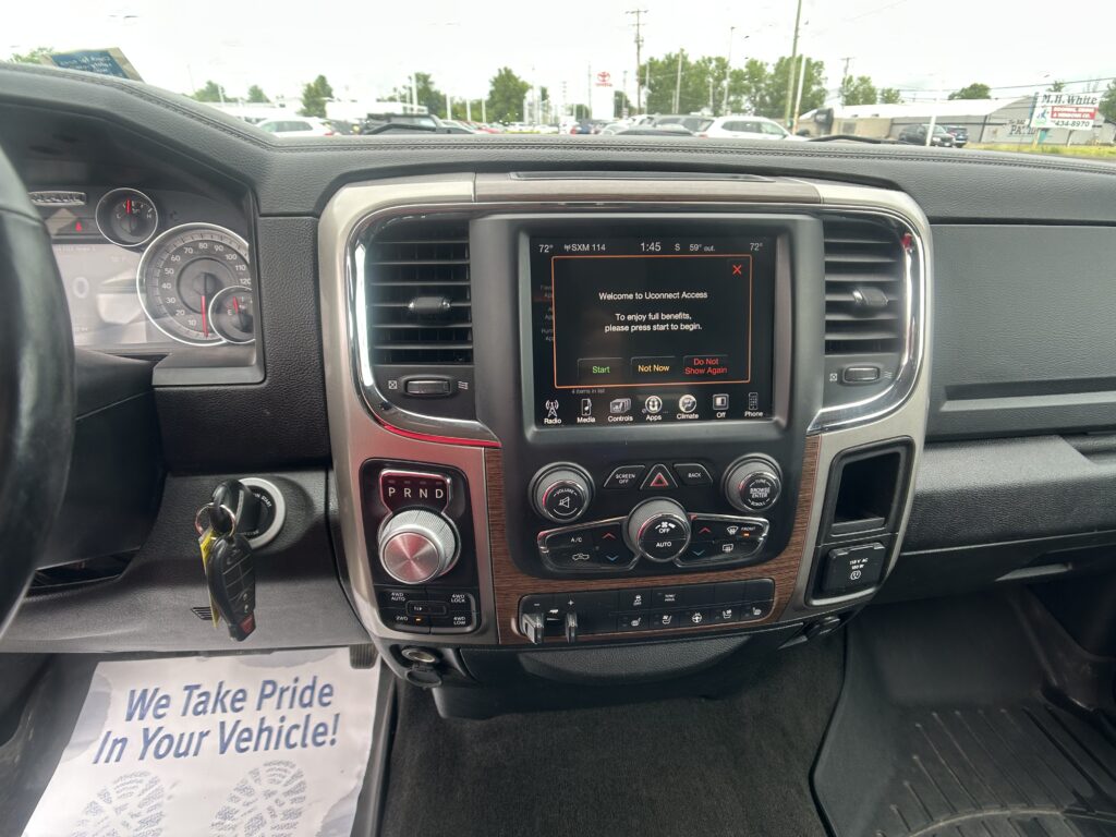 Interior view of a vehicle dashboard showing a centered touchscreen and gear selector (PRND) with a welcome screen on the display.