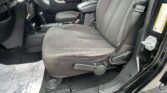 Interior view of a black SUV: front driver and passenger seats with white stitching, center console and gear shifter visible, door panel on the left.