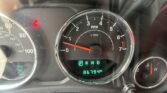 Close-up of a car instrument cluster: tachometer in the center, speedometer on the left, red seatbelt warning illuminated, gear indicator shows P R N D, digital odometer reads 66,794 miles.