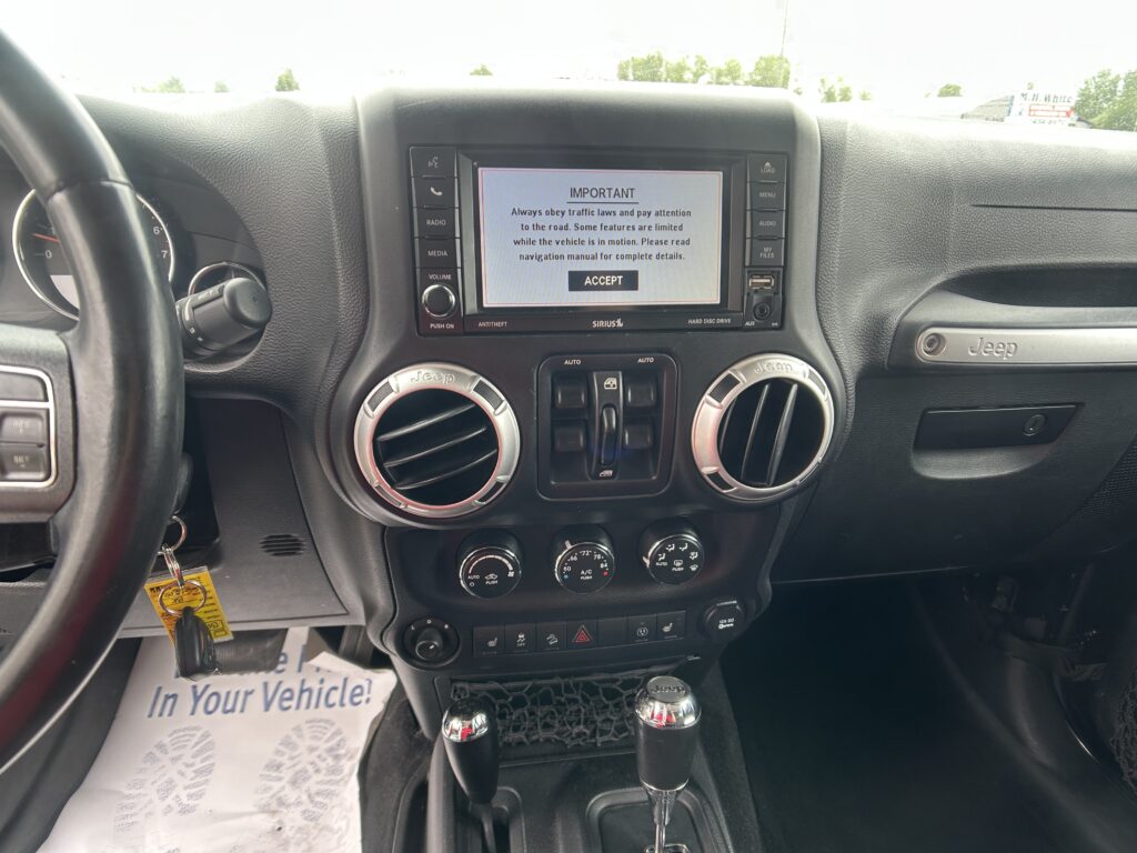 Car dashboard center with touchscreen displaying an important notice and an ACCEPT button, flanked by control buttons and air vents.