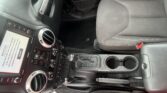 Jeep car interior with center console, touchscreen display, circular air vents, and gear shift visible between front seats.