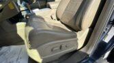 Interior of a beige car showing the driver and passenger seats, center console with gear shifter, and sunlit leather upholstery.