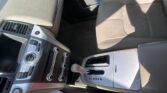 Beige leather car seat and center console with climate controls, gear shifter, and cup holder visible in the front cabin