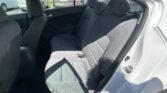 Backseat of a gray car with fabric seats; parking lot visible through windows outside the car doors.