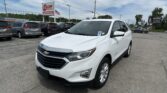 White Chevrolet SUV in the foreground at a car dealership lot with other vehicles and signs in the background.