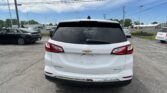 Rear view of a white Chevrolet Equinox SUV in a parking lot with other cars around.