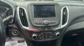 Car interior with a center touchscreen displaying FM radio (88.7 NewYorke) and climate/volume controls nearby, view from the driver’s seat.
