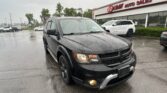 Black Dodge SUV in the foreground on a wet parking lot near an EZ Loan Auto Sales storefront.