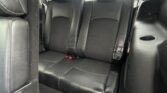Back seat area of a car with black leather seats, two outer seats and headrests, visible seat belts and cup holder on the right side.