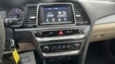 Inside a car cockpit showing the center touchscreen displaying 'AV Off' with menu icons beneath. Dashboard, climate controls, and steering wheel are visible.