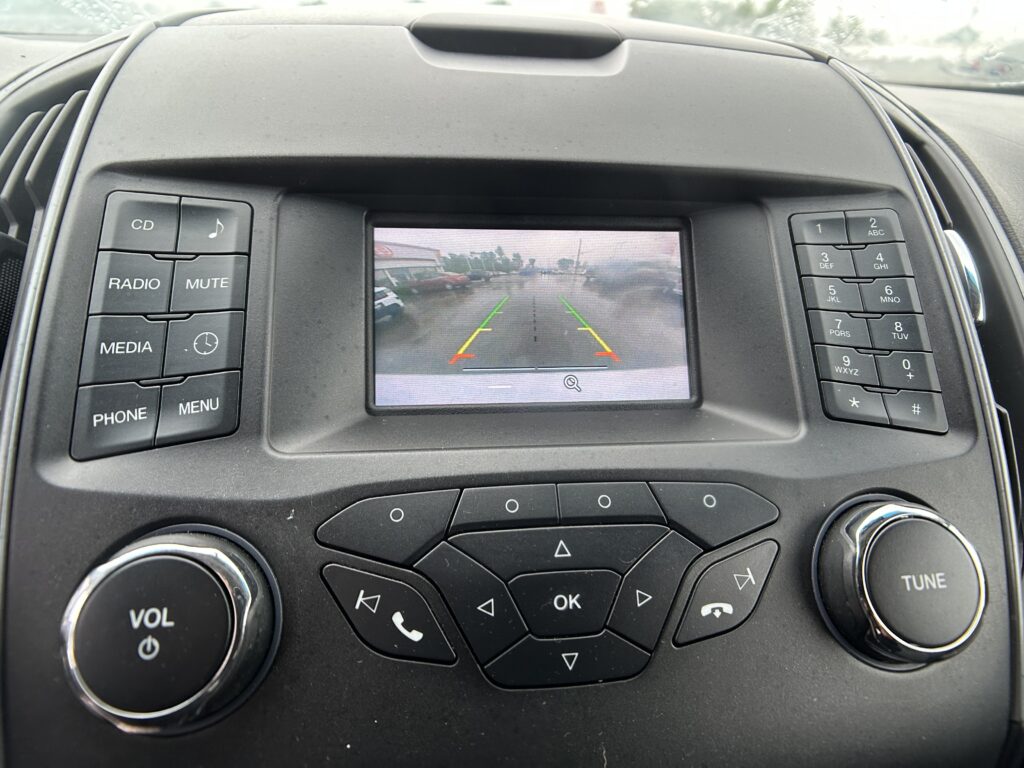 Rear-view camera feed on car display with parking guideline lines in green, yellow, and red.