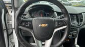 Interior view from the driver’s seat showing the steering wheel, instrument cluster, and center display with raindrops on the windshield.