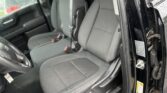 Interior of a black pickup truck with gray cloth seats, driver’s seat and front passenger seat visible, door open.