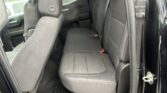 Back seat of a black SUV with gray fabric benches, headrests, and an open rear door revealing the interior.