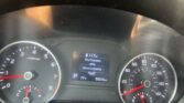 Car instrument cluster: left tachometer, right speedometer, center digital display showing mileage and tire pressure.