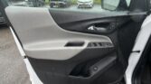 Open car door interior panel with window and lock controls, gray and black dashboard area, raindrops on the window outside.