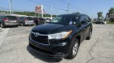 Front-right view of a black SUV in a dealership lot, with several minivans in the background and an EZ Loan Auto Sales sign nearby