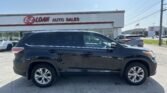 Black SUV in the foreground at the E-Z LOAN AUTO SALES lot with a white dealership building and sign on a sunny day.
