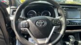 Driver's-seat view of a car interior: steering wheel with controls, instrument gauges, and infotainment screen to the right