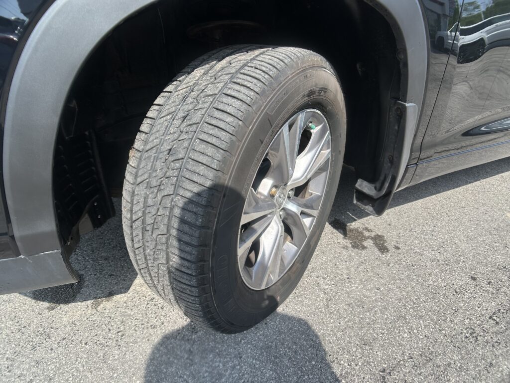 Close-up of a car tire and wheel mounted on a black vehicle, showing tread and rim detail.