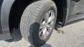 Close-up of a car tire and wheel mounted on a black vehicle, showing tread and rim detail.