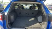 Open blue SUV hatchback with rear cargo area visible and back seats upright in a parking lot.
