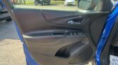 Interior of a car door with window controls visible; outside a parking lot with several vehicles and a side mirror in view