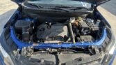Car hood raised showing the engine compartment with an ECOTEC engine, battery, coolant reservoir, and various hoses and belts.