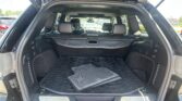 Open SUV trunk with black interior and stacked rubber floor mats in the cargo area, rear seats visible.