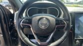 Front view of a Jeep steering wheel with the dashboard and center console visible from the driver's seat.