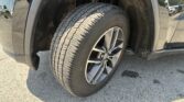 Close-up of a vehicle's wheel and tire in the wheel well, with visible tread pattern and muddy fender area.