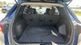 Open hatchback trunk of a blue SUV with rear seats upright and cargo floor visible