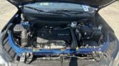 Open car hood revealing the engine bay of a blue vehicle, with the ECOTEC engine cover visible and windshield wipers in view.