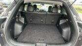 Cargo area of a black SUV with rear seats upright, showing an empty trunk space behind the third row.