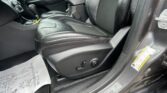 Interior of a car with black leather seats, center console, and gear shifter, plus a paper floor mat on the floor.