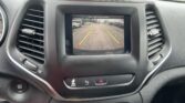 In-dash rear-view camera feed showing parking guidelines (green, yellow, red) on the center touchscreen.