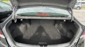 Open trunk of a black Hyundai Sonata, showing the empty cargo space and rear windshield view behind it.